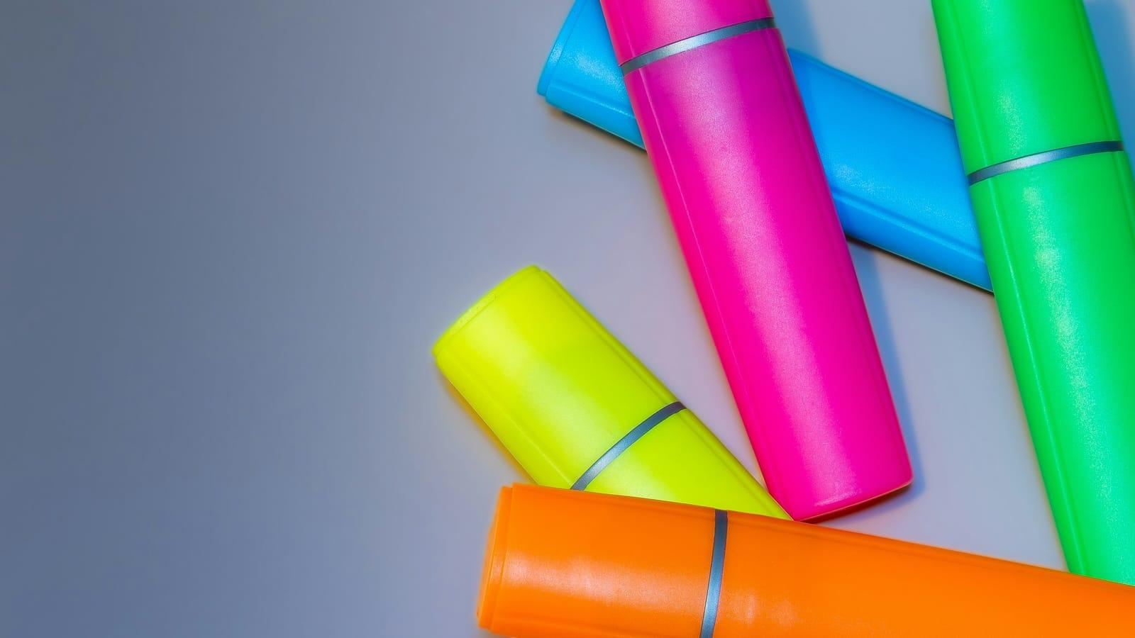 桌面上散落的彩色荧光笔，象征 Turnitin 相似度报告的颜色代码